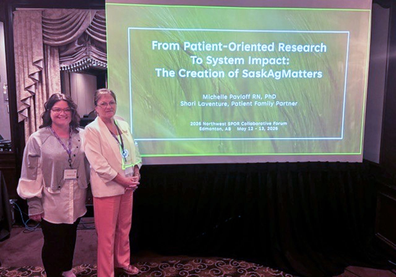 Dr Michelle Pavloff and Shari Laventure beside a presentation screen that says “From Patient-Oriented Research To System Impact: The Creation of SaskAgMatters”